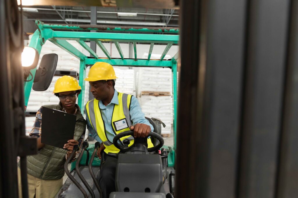 Male and female worker discussing over clipboard in warehouse