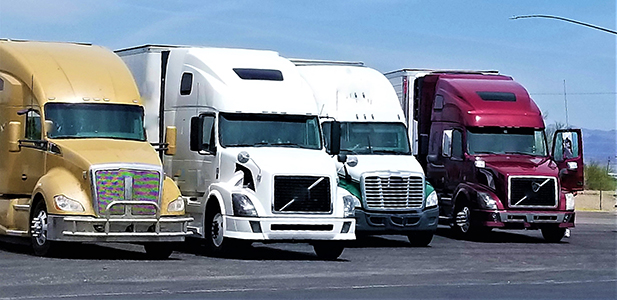 Four semi trucks parked in a line